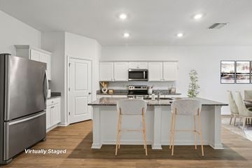 Zephyrhills apartment for rent - A kitchen with white cabinets and a stainless steel refrigerator.
