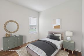 Zephyrhills apartment for rent - A bedroom with a bed, nightstand, and a mirror on the wall.