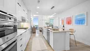 Frisco apartment for rent - A modern kitchen with white cabinets and a large island.