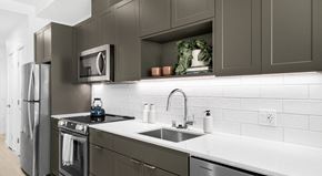 Seattle apartment for rent - A modern kitchen with dark brown cabinets and stainless steel appliances.