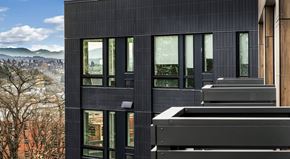 Seattle apartment for rent - A modern building with a black facade and large windows.