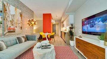 Los Angeles apartment for rent - A living room with a white couch, a red rug, and a television on the wall.