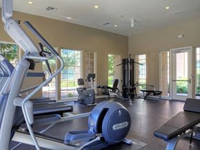 Upland apartment for rent - Three-Bedroom Apartments in Upland, CA - Park Central Apartments - Fitness Center with Cardio Equipment, Recessed Lighting, Large Windows, and a Glass Door.