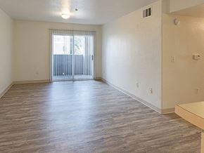 Reno apartment for rent - an empty living room with wood flooring and a sliding glass door