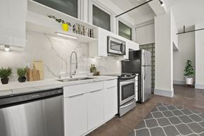 Los Angeles apartment for rent - Downtown LA, CA, Apartments for Rent - Santa Fe Lofts - Modern Loft Kitchen With White Cabinetry, Marble Style Backsplash, Stainless Steel Appliances, And High Ceilings.