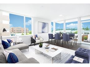 Seattle apartment for rent - Eastlake, WA, Apartments Near Woodland Park Zoo - Shelton Eastlake - Living Room With Large Windows, Gray Sectional Sofa, White Coffee Table, And Dining Area.