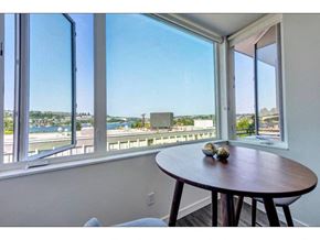 Seattle apartment for rent - Seattle, WA, Apartments Near Pike Market Place - Shelton Eastlake - Dining Area With Hardwood Floor, Round Table, Large Windows, and Stunning Lake Union and Seattle Skyline Views.