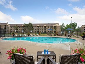 Fridley apartment for rent - a swimming pool with chairs and tables around it