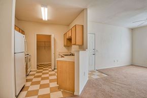 Beaumont apartment for rent - Beaumont, TX Apartments – Breakwater Bay - Kitchen with tile flooring, stainless steel sink, plenty of cabinets for storage, oven/stove top, fridge, pantry. Living room with plush carpet.