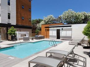 Santa Clara apartment for rent - Two-Bedroom Apartments in Santa Clara, CA - Santana Terrace - Swimming Pool with a Fireplace, Lounge Seating, and Lush Landscaping
