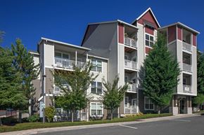 Portland apartment for rent - a street view of an apartment building with trees