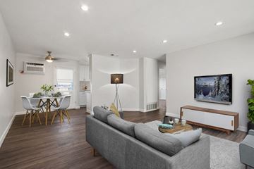 Downey apartment for rent - A living room with a grey couch and a white table.