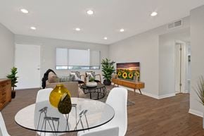 Downey apartment for rent - A modern dining room with a glass table and white chairs.