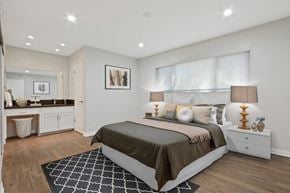 Downey apartment for rent - A bedroom with a large bed and a rug on the floor.