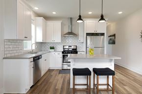 Maple Grove apartment for rent - A modern kitchen with white cabinets and a wooden floor.