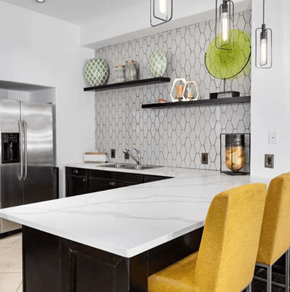 Woodbridge apartment for rent - Modern kitchen with white quartz countertop, black cabinets, honeycomb tile backsplash, and yellow bar stools.