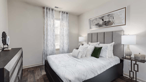 Woodbridge apartment for rent - Modern bedroom with gray headboard, white bedding, and neutral decor.