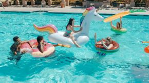 Denver apartment for rent - People are enjoying a sunny day at the pool with inflatable unicorn floats.