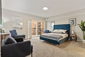 Des Plaines apartment for rent - A bedroom with a large bed and a chair.