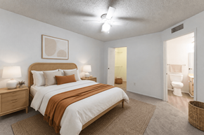Tallahassee apartment for rent - A bedroom with a bed, nightstand, and a ceiling fan.