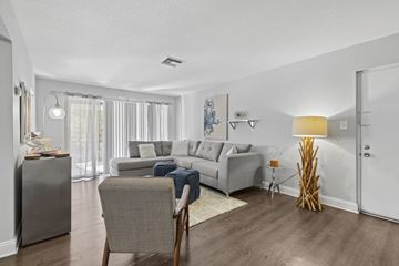 Tampa apartment for rent - A living room with a grey couch and a chair.