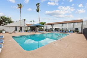 Tucson apartment for rent - A large swimming pool with a blue cover and a building in the background.
