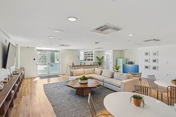 Miami apartment for rent - A modern living room with a white coffee table and a grey rug.