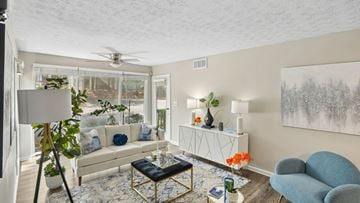 Stone Mountain apartment for rent - A living room with a white couch, a blue chair, and a painting on the wall.