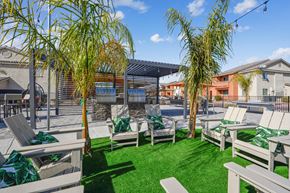 Las Vegas apartment for rent - A sunny day at the outdoor seating area with green grass and trees.