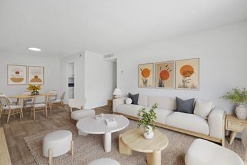 Lake Worth Beach apartment for rent - A living room with a white couch, a coffee table, and a dining table with chairs.