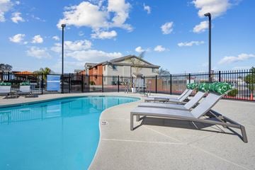 Las Vegas apartment for rent - A pool with a sun lounger and a building in the background.