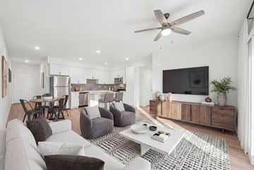 Henderson apartment for rent - A modern living room with a grey sofa, a white coffee table, and a television on a wooden cabinet.