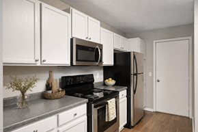 Burnsville townhouse for rent - Virtually staged kitchen at Summit Townhomes in Burnsville, MN, with white cabinets and stainless steel appliances.