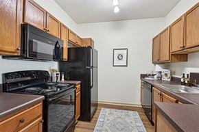 Hinesville apartment for rent - Fully equipped kitchen with black appliances and wood cabinetry in Tattersall Village Apartments, Hinesville, GA