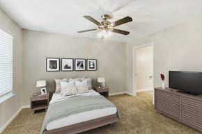Peachtree City apartment for rent - Bedroom with carpet, ceiling fan, and large windows letting in natural light at The Greens at Braelinn in Peachtree City, Georgia.