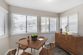 Peachtree City apartment for rent - furnished dining room with three windows and a wooden table and chairs