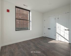 Stamford apartment for rent - Empty apartment room with hardwood flooring, white walls, and a single large window.