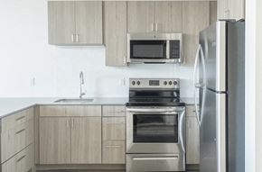 Stamford apartment for rent - Modern kitchen with light wood cabinets, stainless steel appliances, and a white backsplash.