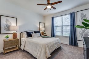 Grand Prairie apartment for rent - an empty bedroom with a bed and a ceiling fan