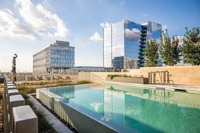 Frisco apartment for rent - A swimming pool with a glass building in the background.