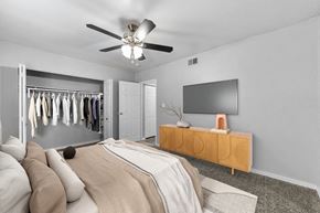Overland Park apartment for rent - Pet-Friendly Apartments in Overland Park– Treetop Lodge – A bedroom with a bed, a TV, and a wardrobe.