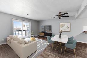 Overland Park apartment for rent - Apartments in Overland Park, KS 66214 for Rent – Treetop Lodge - A living room with a white couch, a white coffee table, and a ceiling fan.