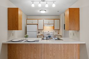 Coon Rapids apartment for rent - a kitchen with white appliances and wooden cabinets