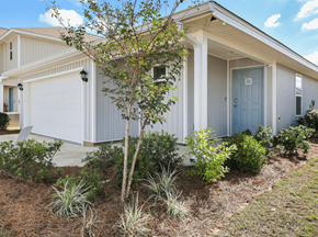 Foley apartment for rent - a house with a blue door and a tree in front of it