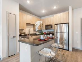 Las Vegas apartment for rent - A kitchen with a refrigerator, sink, and a dining table with chairs.