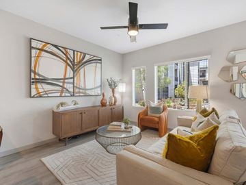 Las Vegas apartment for rent - A living room with a large abstract painting on the wall, a white sofa, and a glass coffee table.