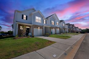 Taylors apartment for rent - Row of modern townhouses at dusk with a pink and blue sky.