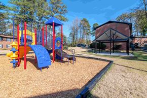 Atlanta apartment for rent - A playground with a blue and yellow slide and a red and yellow climbing frame.