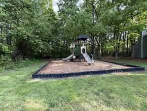 Greensboro apartment for rent - A playground with a slide and a swing set in a grassy area.