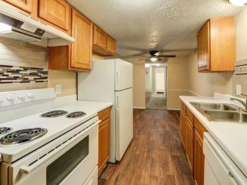 Derby apartment for rent - a kitchen with white appliances and wooden cabinets